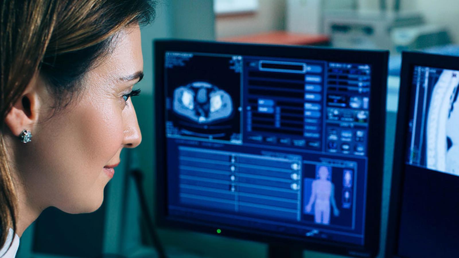 Doctor looking at computers showing body scan images 